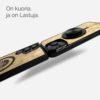 Ainutlaatuinen visakoivuinen puhelinkotelo iPhonelle, Samsungille, OnePlussalle ja Google Pixelille. Kestävä ja tyylikäs suojus kameralle ja näytölle. Kuoriosa mustaa muovia, puuosa luonnollista visakoivua. Kuvan yläpuolella teksti suomeksi. Lastu