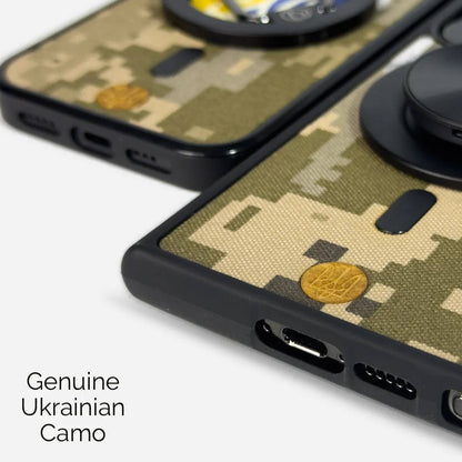 Aito ukrainalainen digitaalinen maastokuvioinen puhelinkotelo MM14-kankaasta. Näytetään iPhone ja Samsung -puhelimille. Kotelon takana on kultainen logo. Saatavilla eri malleille, mukaan lukien OnePlus ja Google Pixel. Lastu