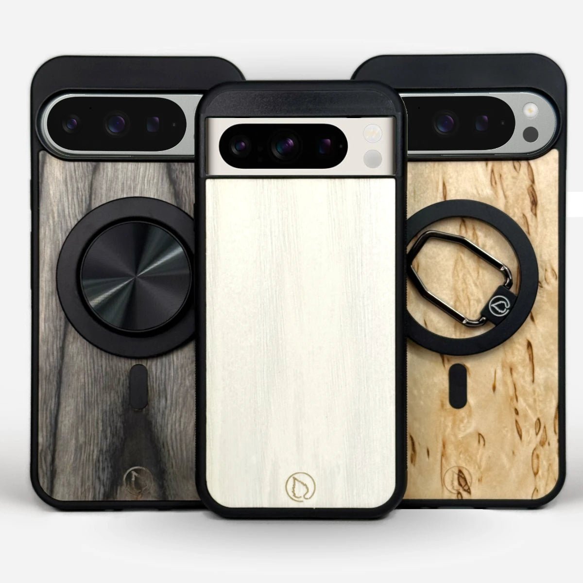 Puhelimen kuoret, Lastu kuoret, MagSafe kuoret - Kolme puista Google Pixel suojakuorta MagSafe-renkaalla, harmaa, valkoinen ja vaalea. Lastu Genuine Nordic Wooden Cases.

Translation explanation (not part of alt text):
This alt text in Finnish describes "Three wooden Google Pixel protective cases with MagSafe ring in grey, white, and light colors. Lastu Genuine Nordic Wooden Cases." The text includes the required SEO keywords at the beginning and