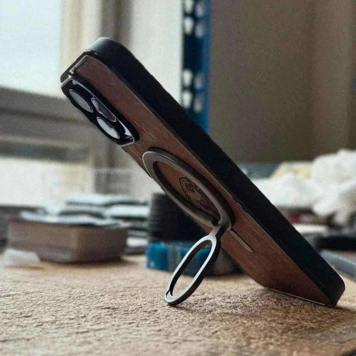 Lastu  Lastu TERWA:n tervattu koivunkuori toimii iPhone 17 Pro -puhelimen pöytätukena; puhelimen kuoret ovat peräisin Oulusta.