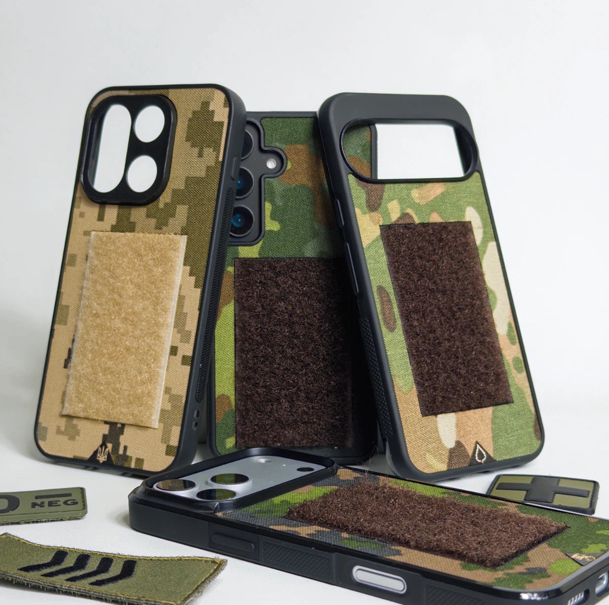Lastu  Lastu VELCRO puhelimen kuoret sotilaskankaasta iPhone 17 Pro, Galaxy S26, OnePlus 15 valkoisella taustalla